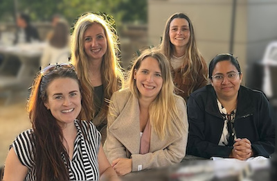 Group photo of 2023 UCI WIR Organizing Board: (from left to right) Alie Male, Jenna Adams, Maren Pein, Belén Torrado, and Asha Densi. All five women are facing camera while smiling.